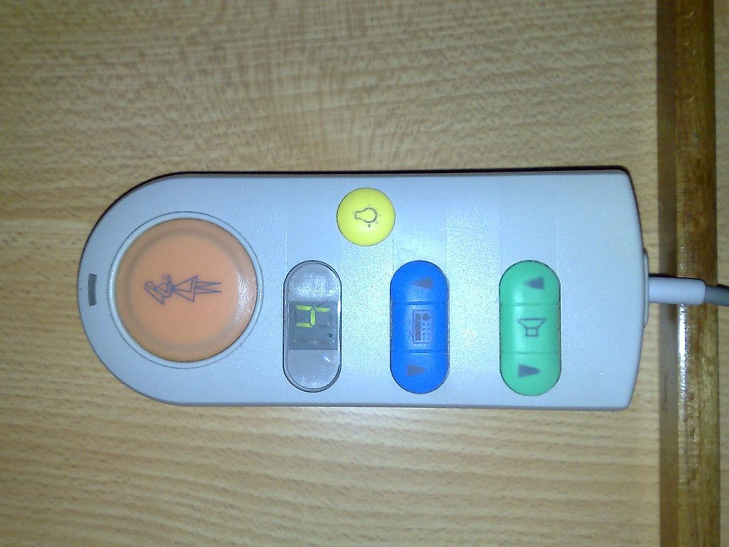 Controle de cama hospitalar com botões para subir e descer a cabeceira